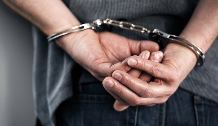 In handcuffs, in custody